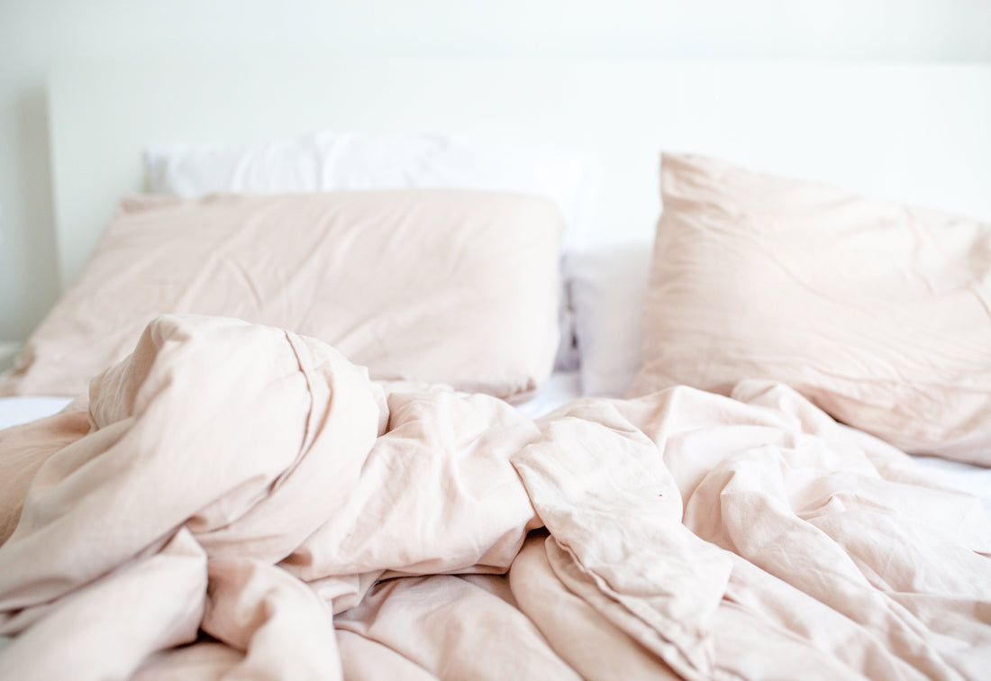 pink and beige tone bed with messy sheet in the morning