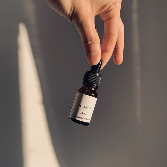 Hand holding a dropper bottle with a neutral background
